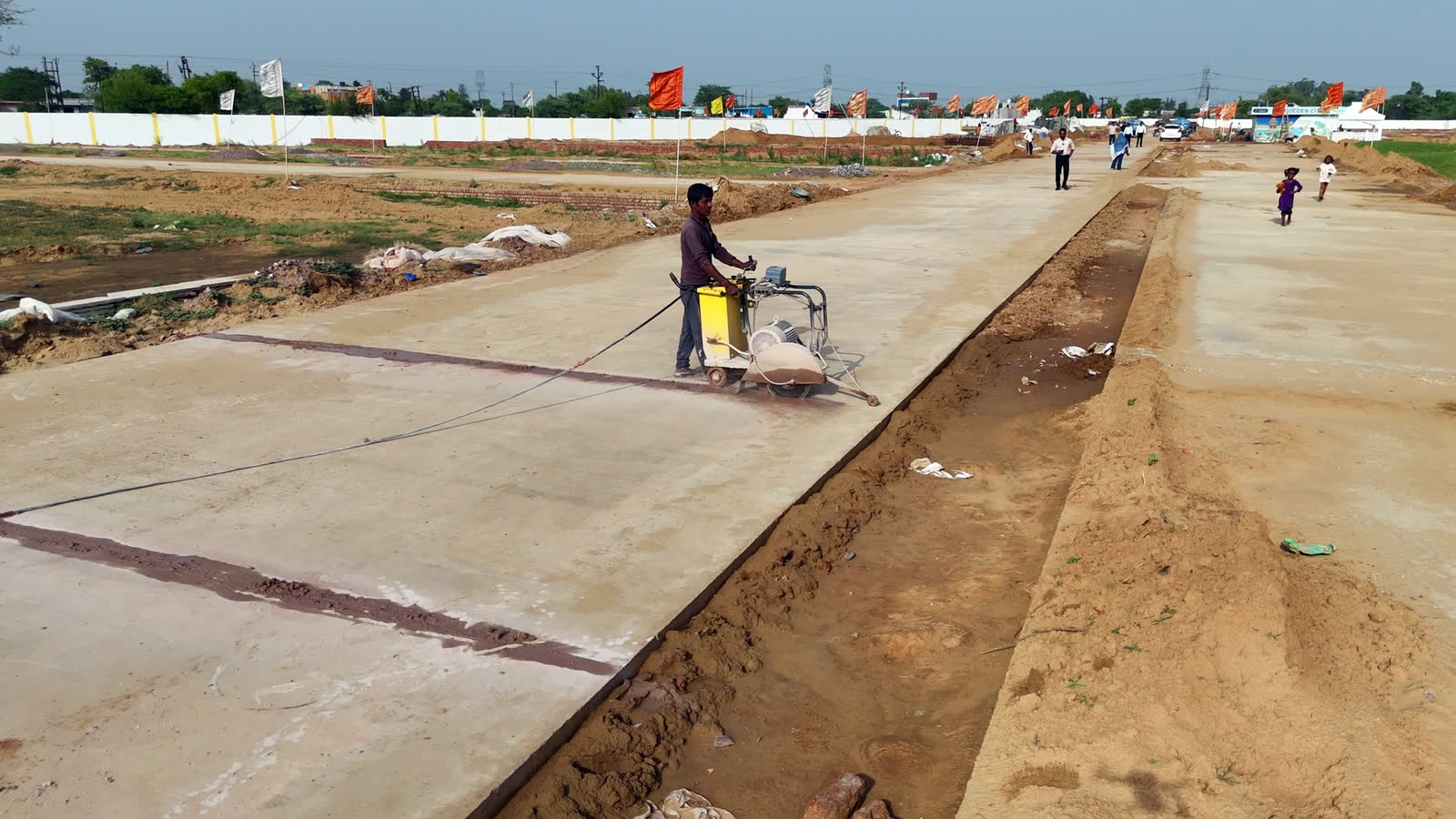 Worker finishing a concrete road surface on site